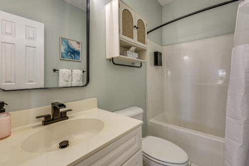 a bathroom with a sink and a toilet and a mirror at Golf, Gamble and Fish! Condo with Pool in Little River in Little River