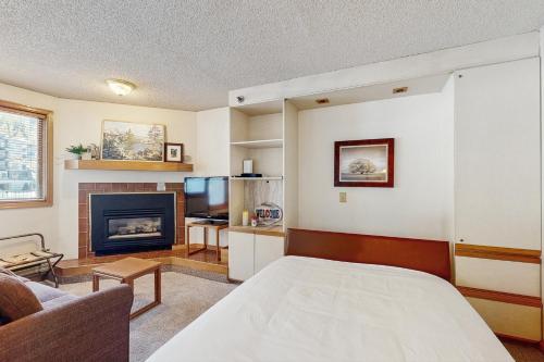 a living room with a bed and a fireplace at Iron Horse Resort #C1083 in Winter Park