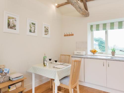 a kitchen with a table with two chairs and a table at Bilsdale - 25566 in Nether Silton