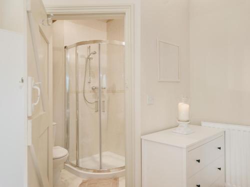 a white bathroom with a shower and a toilet at Bilsdale - 25566 in Nether Silton