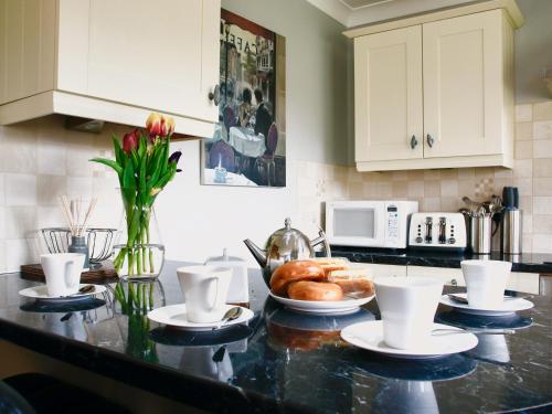 a kitchen with a counter top with a bowl of bread at Willow Cottage in Bentley