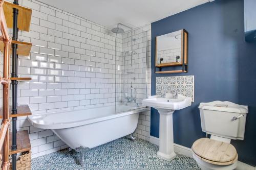 a bathroom with a tub and a toilet and a sink at 4 Bed in Rottingdean oc-bbrott in Rottingdean