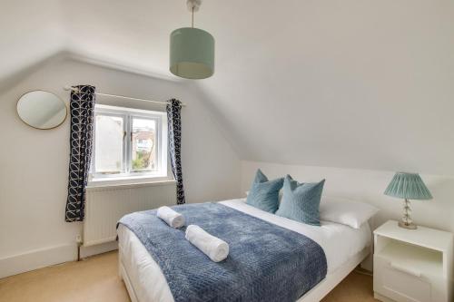 a bedroom with a blue and white bed and a window at 4 Bed in Rottingdean oc-bbrott in Rottingdean