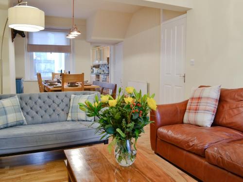 a living room with a couch and a vase of flowers at Gilbert's Warrant in Keswick