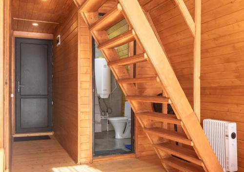 a staircase leading to a bathroom with a toilet at Rock Cabins Svaneti in Mestia