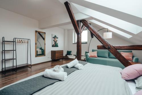 a bedroom with a large bed and a blue couch at Apartmá Oberleithnerův palac in Šumperk