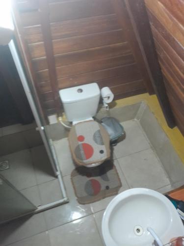 a small bathroom with a toilet and a sink at chalé alpino in Saquarema