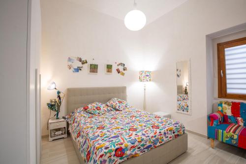 a bedroom with a bed with a colorful comforter at CasAmica by BarbarHouse in Vieste
