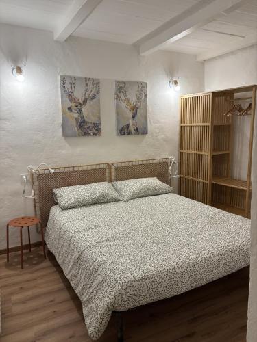 a bedroom with a bed and two paintings on the wall at Charme a Corniglio in Corniglio