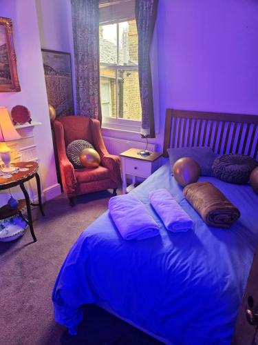 a bedroom with a bed with pillows and a chair at The blue international inn in London