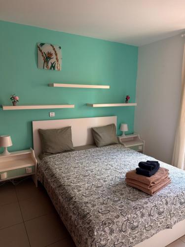 a bedroom with a bed with a blue wall at Cali in Alcalá