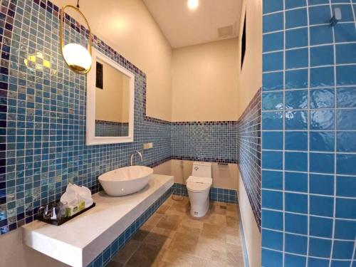 a blue tiled bathroom with a sink and a toilet at The white mountain pool villa Ao Nang in Ban Thai Thai