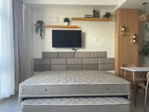 a bedroom with a bed and a flat screen tv at Mactan Plains condo unit in Punta Engaño