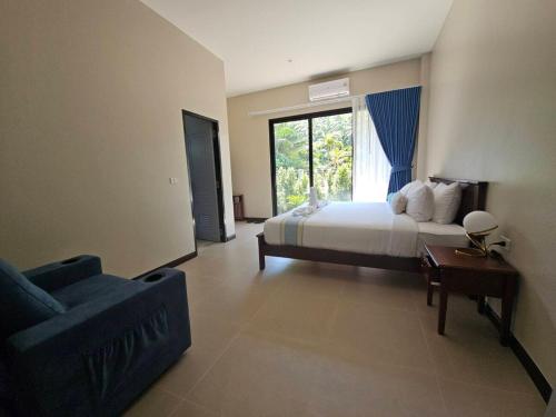 a bedroom with a bed and a couch and a window at The white mountain pool villa Ao Nang in Ban Thai Thai