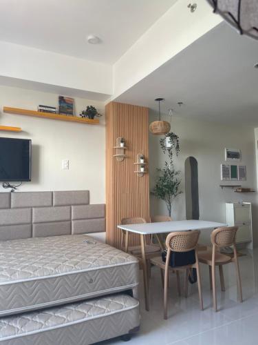 a bedroom with a bed and a table and chairs at Mactan Plains condo unit in Punta Engaño