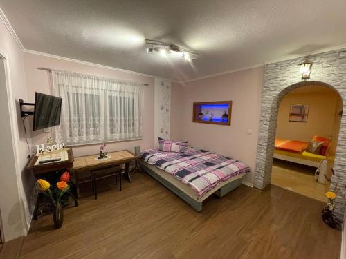a bedroom with a bed and a table and a desk at Ferienwohnung ILSENHOF in Königsbrück