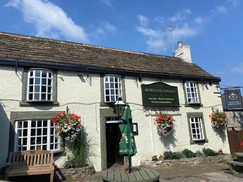 a white building with a bench in front of it at Ye Olde Bowling Green Inn in Bradwell