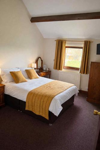 a bedroom with a large bed and a window at Ye Olde Bowling Green Inn in Bradwell