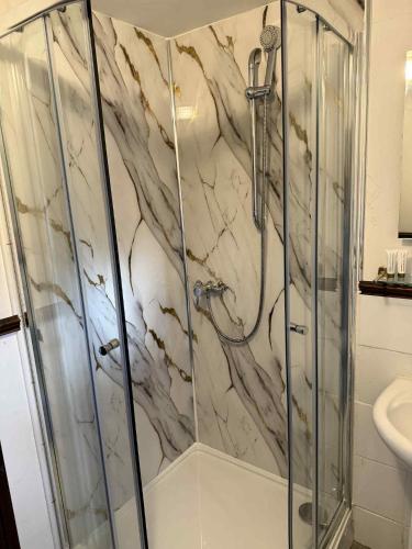 a bathroom with a shower with a marble wall at Ye Olde Bowling Green Inn in Bradwell