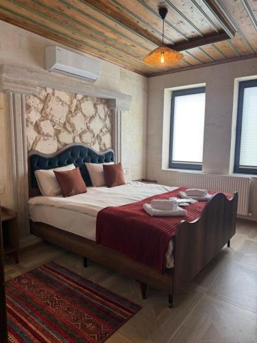 a bedroom with a large bed with a red blanket at ELEGANT HOUSE Cappadocia in Göreme