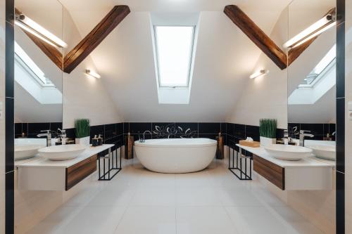 a bathroom with three sinks and a large tub at Apartmá Oberleithnerův palac in Šumperk