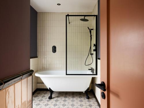 a bath tub in a bathroom with a shower at The Brackenrigg Inn in Watermillock