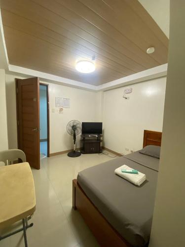 a bedroom with a bed and a desk with a fan at Hotel Marinduque in Boac