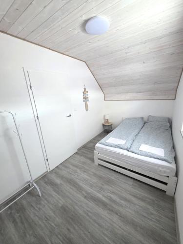 a bedroom with a bed in a white room at Domki Rajski Wypoczynek z basenem in Jastrzębia Góra