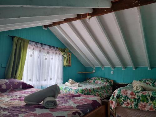 a room with two beds and a window at Cabañas Jade in Cochamó