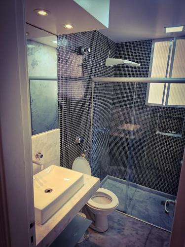 a bathroom with a shower and a toilet and a sink at 2 BEDROOM Condo -IPANEMA in Rio de Janeiro