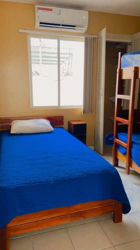 a bedroom with a blue bed and a window at Apartamento playa Tonsupa in Tonsupa