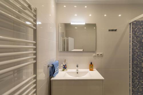 a white bathroom with a sink and a mirror at RentitSpain - Nerja - Apartamentos Vistas Únicas al Mar Mediterráneo in Nerja