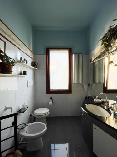 a bathroom with two toilets and two sinks and a window at Dimora Marisa in Albiate