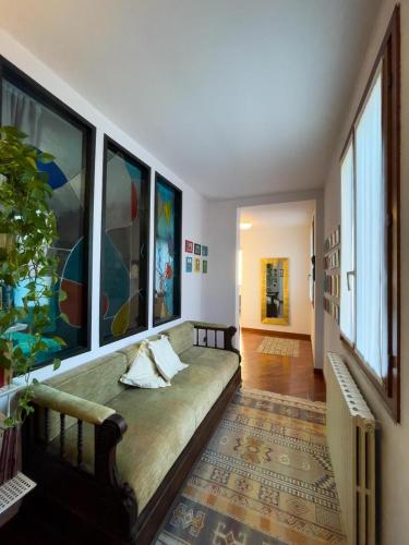 a living room with a couch and some windows at Dimora Marisa in Albiate