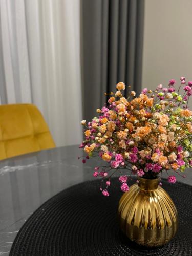 a vase filled with flowers sitting on a table at Golden corner in Plungė