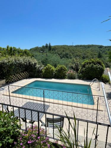 una piscina con tavolo e sedie accanto di Le Logis d'Eve a Najac