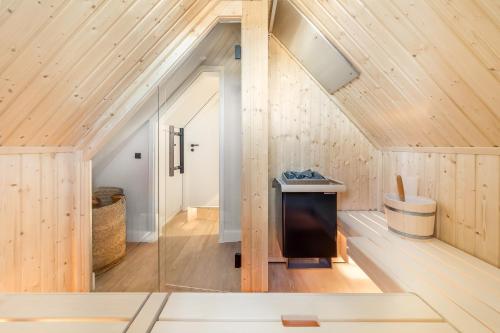 an attic room with wood paneling and a glass wall at Mare in Hörnum