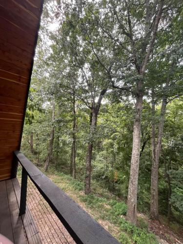 a balcony with a view of the woods at Post Oak Perch-Cozy Forest A-frame Near Bentonville in Rogers