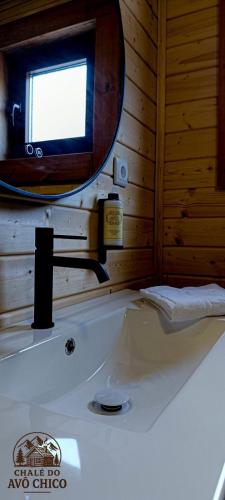 a bathroom with a tub and a mirror and a sink at Chale do Avô Chico Penhas da Saúde in Penhas da Saúde
