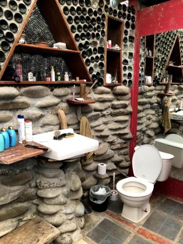 a stone bathroom with a sink and a toilet at Open spacious house with stunning Peninsula view in Pavones