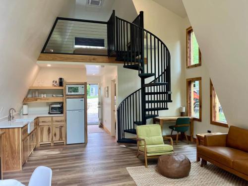 a kitchen and a living room with a spiral staircase at Running Spring Retreat-Cozy Forest A-Frame near Bentonville in Rogers