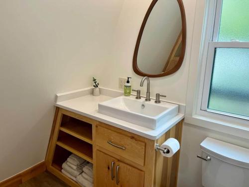 a bathroom with a sink and a mirror at Running Spring Retreat-Cozy Forest A-Frame near Bentonville in Rogers