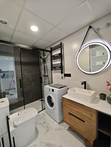 a bathroom with a washing machine and a washer at Sea&Skyline Suites Benidorm in Benidorm