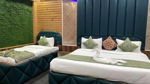 two beds with a swan laying on top of them at Hotel Shuhrah-I-Afaq - Near Srinagar Airport in Baghwānpur