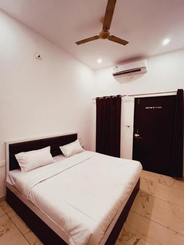 a large bed in a room with a ceiling fan at Vasudeva Villas in Udaipur