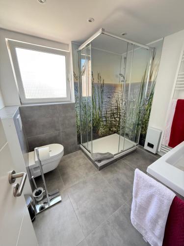 a bathroom with a shower and a toilet and a sink at Ferienwohnung Haus Grenzwald in Nettetal