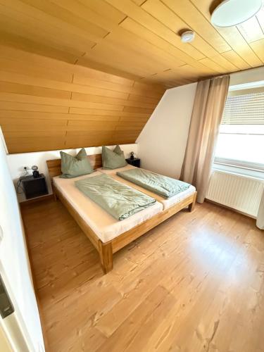 a bed in a room with a wooden ceiling at Ferienwohnung Haus Grenzwald in Nettetal