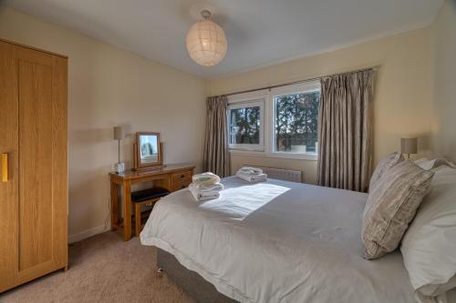 a bedroom with a bed and a desk and a window at The Fairways House in Glenrothes