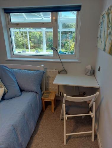 a bedroom with a bed and a desk with a desk at Double bedroom with ensuite wet room, incl breakfast, in Woking in Woking