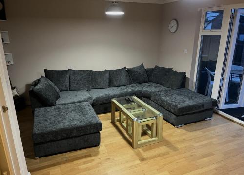 a living room with a couch and a table at Entire Family Entertainment Holiday Home - 3 x Floors - Free Parking - Games Room - Private Garden - Workspace and Wifi 112mb - Self Check-in in Ashford